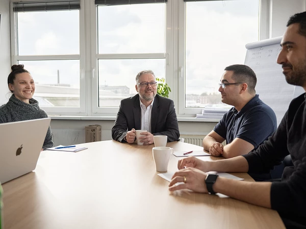 Teammeeting mit Kaffee und Notizen im Konferenzraum